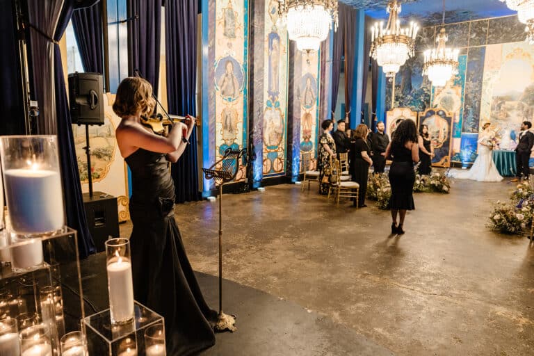 Wedding ceremony inside The Ruins, with painted walls and chandeliers